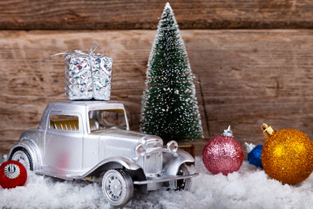Car is carrying Christmas presents. Christmas background with snow, Christmas trees balls and auto.の写真素材