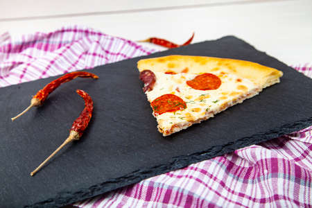 Pizza on a black slate serving platter. Delicious food.