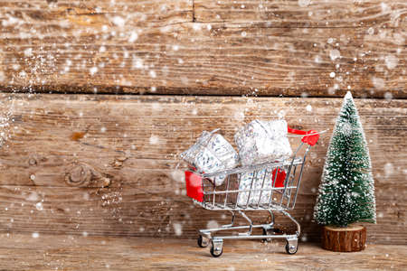 Pig piggy bank and Christmas balls in the snow on an old wooden background. New Year card.の写真素材