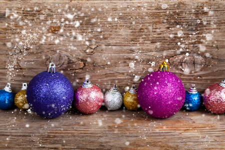 Pig piggy bank and Christmas balls in the snow on an old wooden background. New Year card.の写真素材
