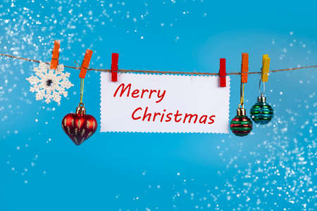 Christmas decorations hang on a rope on a blue background. Place for your text. Christmas card.の写真素材