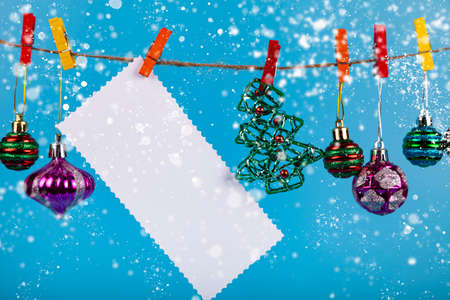 Christmas decorations hang on a rope on a blue background. Place for your text. Christmas card.の写真素材