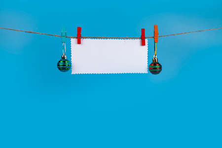 Christmas decorations hang on a rope on a blue background. Place for your text. Christmas card.の写真素材