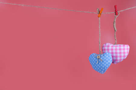 Two hearts on a rope on a pink background. Place for your text. Valentine's day card.の写真素材