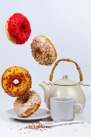 Flying donuts and tea on a white background. Tasty breakfast.の写真素材