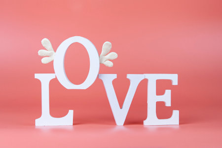 Word Love on a pink background. Letter O flies with wings. Valentine's day card.の写真素材