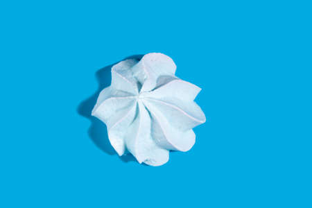 White meringue with a shadow on a blue background. Delicious dessert.の写真素材