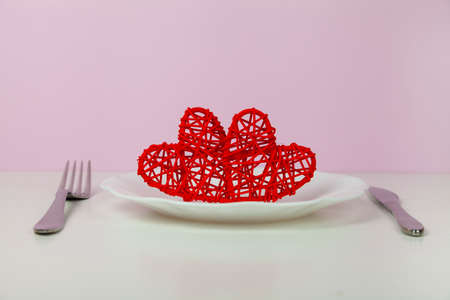 Valentine's day romantic dinner with red hearts on pink background. copyspace.の写真素材