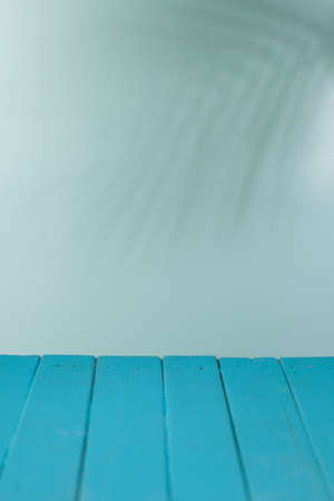 Beautiful blue wood background with the shade of palm trees. Wooden vintage style texture. Wide angle rustic wallpaper or web banner with copy space.の写真素材