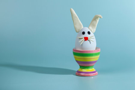 easter greeting card. Easter egg with bunny ears on a stand. Green background, place for your text.の写真素材