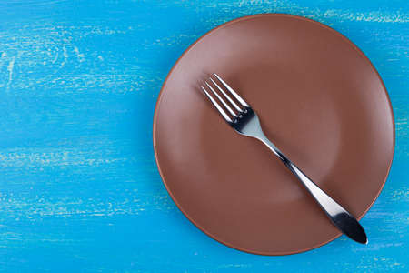 Festive set of cutlery knife and fork with a brown plate, blue background, flatley, copyspaceの写真素材