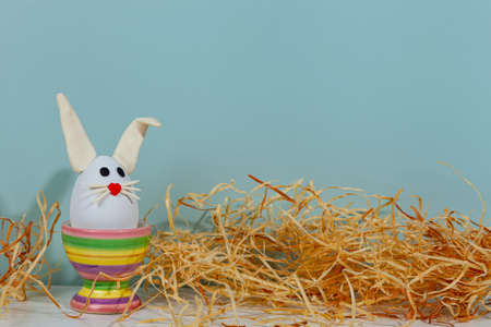 easter greeting card. Easter egg with bunny ears on a stand. Green background, place for your text.の写真素材