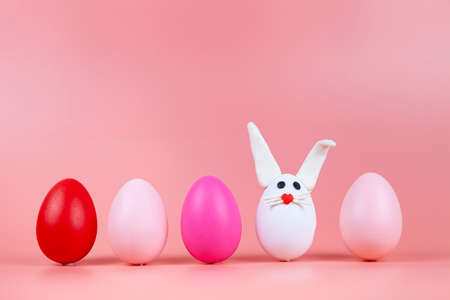 Easter eggs in the form of a rabbit on a pink background. Place for your text.の写真素材