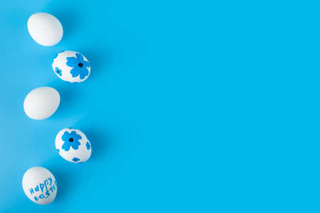 Easter card design. Easter eggs decorated with flowers on blue background. Flat lay, top view, copy space.の写真素材