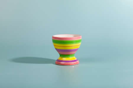 Striped egg cup on a green background. close-up.
