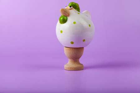 Easter card design. Easter chick on a stand on lilac background.