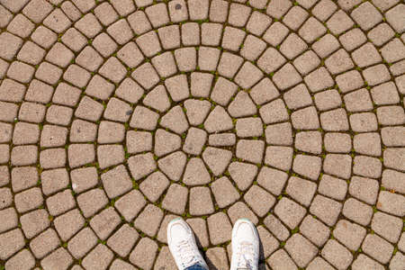 Woman feet on the old stone road