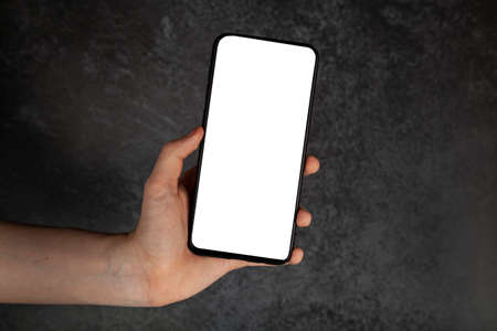 smartphone in hand. White screen, copy space, dark background.
