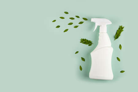 White bottle mockup for cleaning. Eco spray bottle for safe cleaning with green leaves on green background. Copy space, flat lay.の写真素材