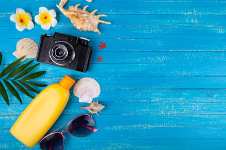 Composition with sunscreen, glasses, camera and seashells