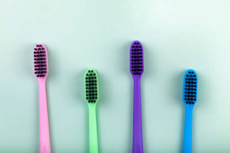 Multicolored toothbrushes a on a green background. Concept of cosmetic products for dental care....
