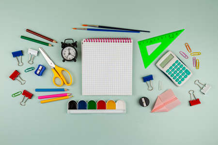 Back to school concept. Frame made of colorful school or office supplies on green table. Flat lay,...