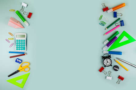Back to school concept. Frame made of colorful school or office supplies on green table. Flat lay, top view, copy space.の写真素材