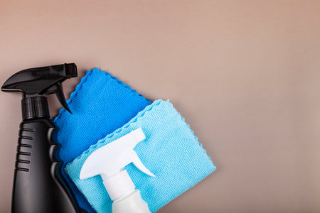 Black and white bottle and cleaning rags. Eco sprayer for safe cleaning on a pastel brown background. Copy space, flat lay.の写真素材