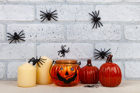 Photo frame mockup with autumn decorations and pumpkins on brick wall background. Thanksgiving, Halloween holiday poster design. Spiders on the wall.の写真素材