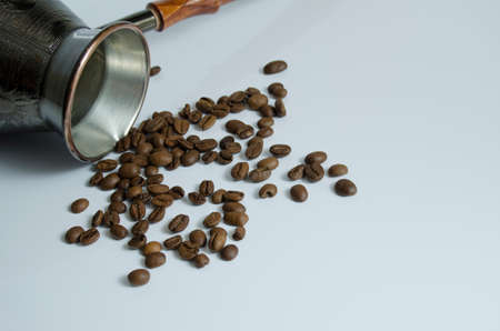 Coffee grains and copper turk for brewing coffee on a white backgroundの写真素材