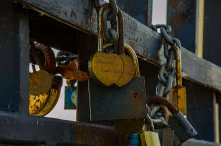 Rusty iron locks on the rail of the bridge. Wedding traditions. Love symbol