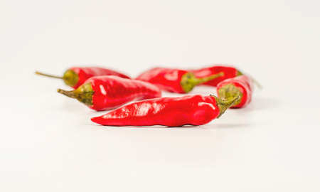 A group of several red hot peppers on a light background. Close-up. Spice. Vegetarianism