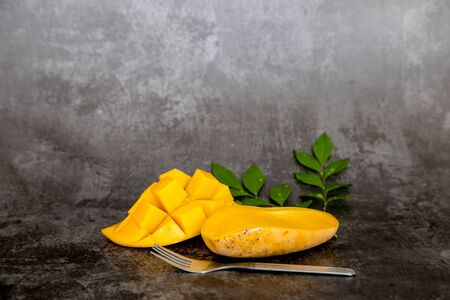 Sweet yellow mango on dark background.