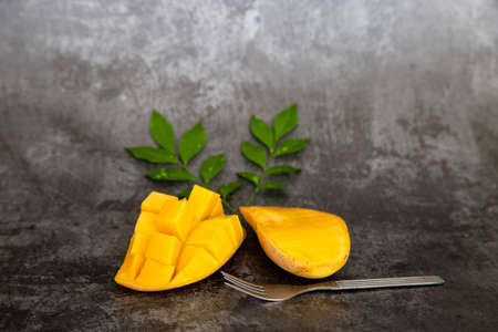 Yellow mango ready to eat on dark background.