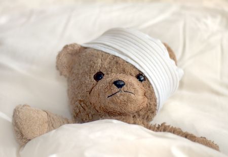 Photo of a teddy bear with bandageの写真素材