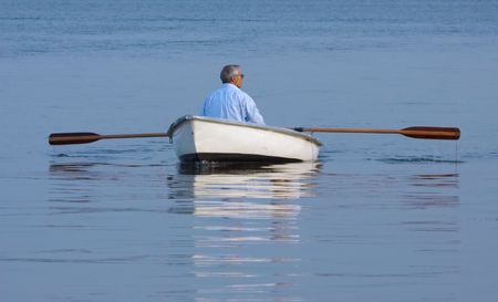 A man in a boat on calm waterの写真素材
