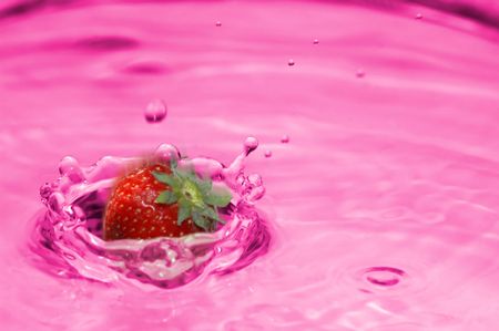 A strawberry drops into lemonadeの写真素材