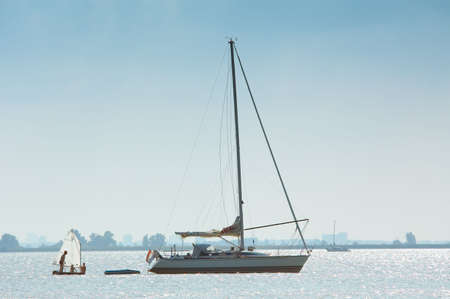 a very small and a big sailboatの写真素材