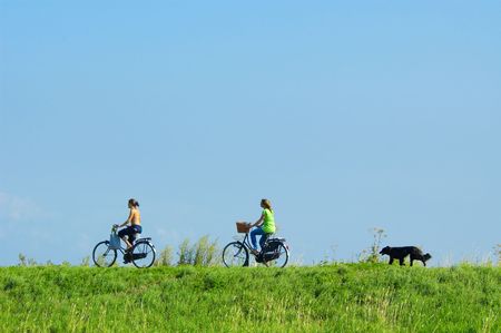 cycling on a summerday with a dog running behindの写真素材