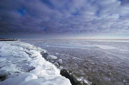 A cold day in winter at a lake covered with iceの写真素材