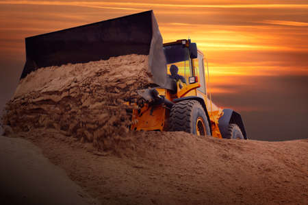Bulldozer at work with sunset backgroundの写真素材