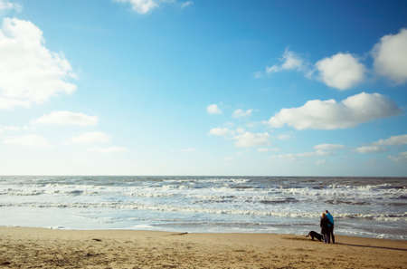 couple with dog on the beach の写真素材