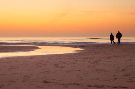people enjoying the sunset on the beach