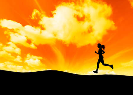 silhouette of  a woman running with sunsetの写真素材