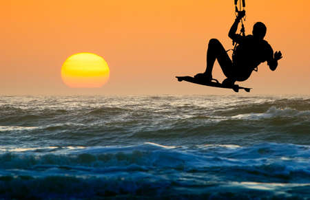 kite boarder in action and sunsetの写真素材
