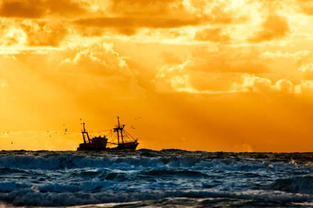 fishing ship at sea with sunset の写真素材