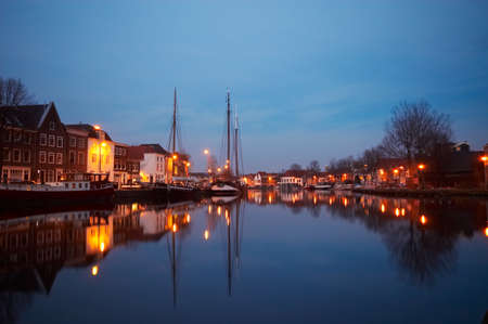 boats and typical dutch houses on the canalの写真素材