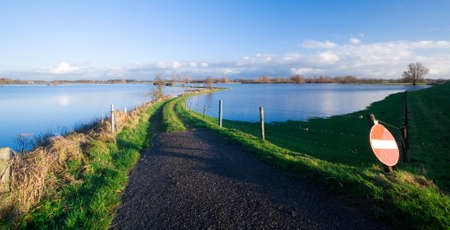 a road into a flooded river (IJssel river Netherlands)の写真素材