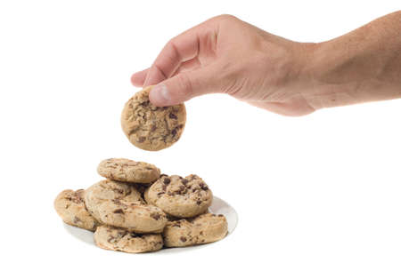 a hand about to get some chocolate chip cookies isolated on a white background