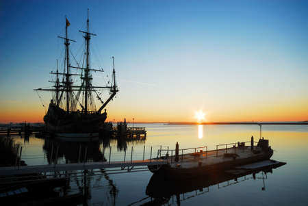 an old ship in the harbor at nightの写真素材